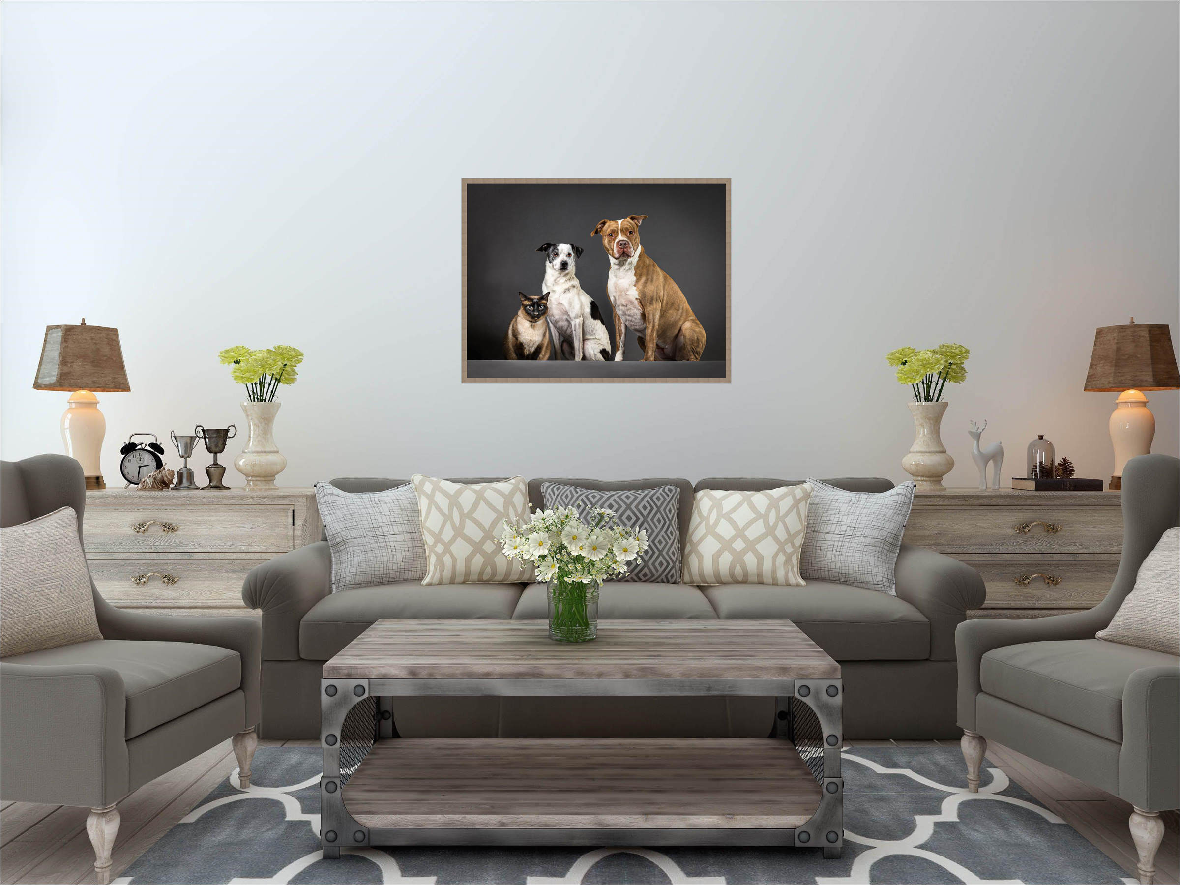 A photo of a sofa with a pet portrait photo of two dogs and a cat on the wall behind